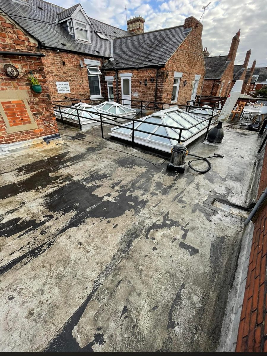 Flat roof terrace with worn, patched felt covering