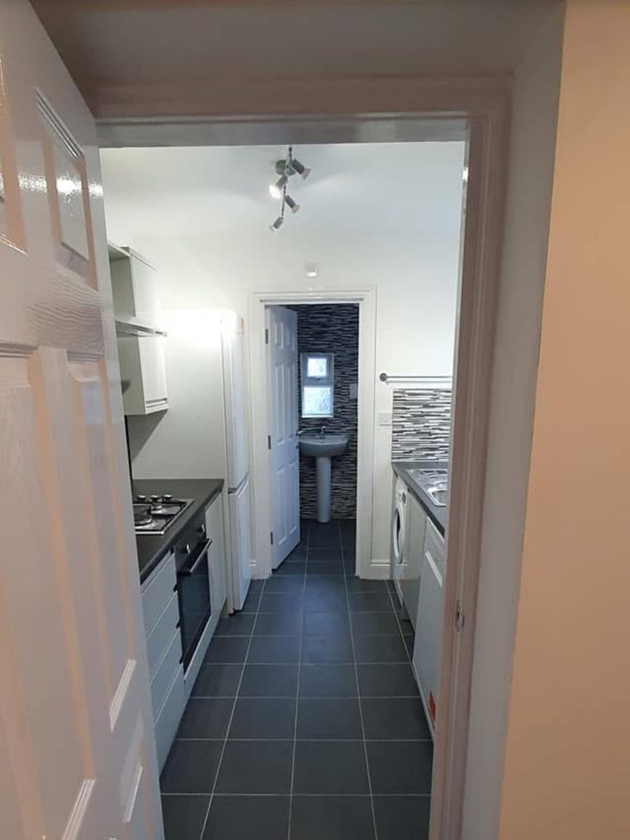 The finished galley kitchen with the new bathroom beyond
