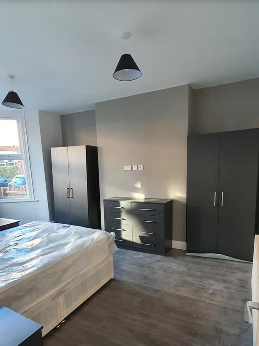The renovated bedroom with new flooring and full redecoration
